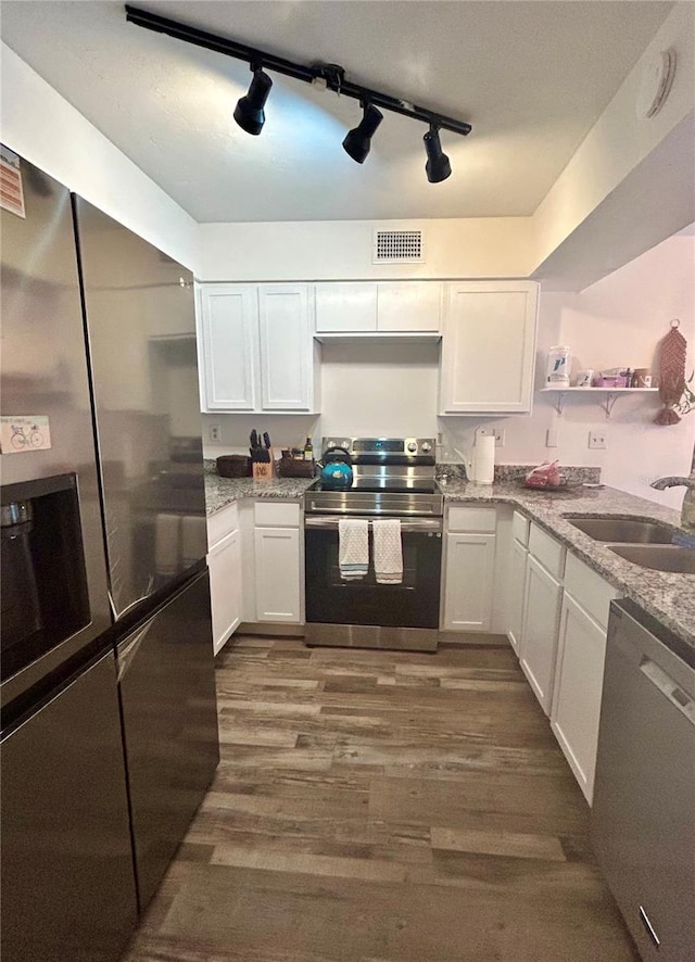 2214 NE 45th Ave Unit 3, Ocala, FL 34470 - kitchen with open shelves, appliances with stainless steel finishes, white cabinetry, dark wood-style flooring, and light stone countertops