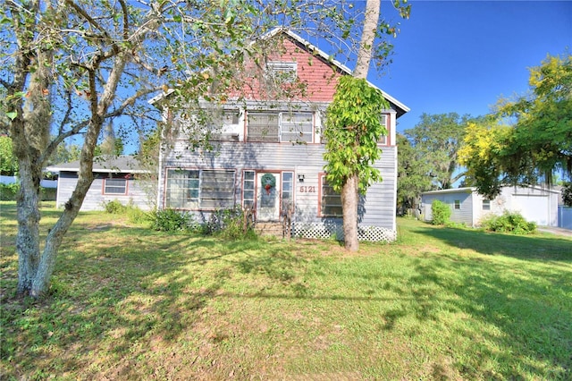 rear view of property featuring a lawn