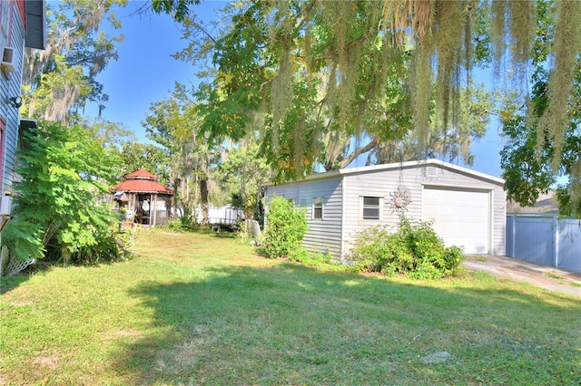 view of yard featuring a garage and an outbuilding