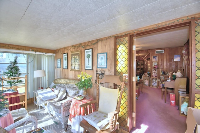 living room featuring carpet flooring and wood walls