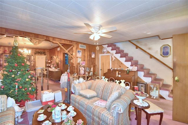 living room with carpet, ceiling fan, and wood walls