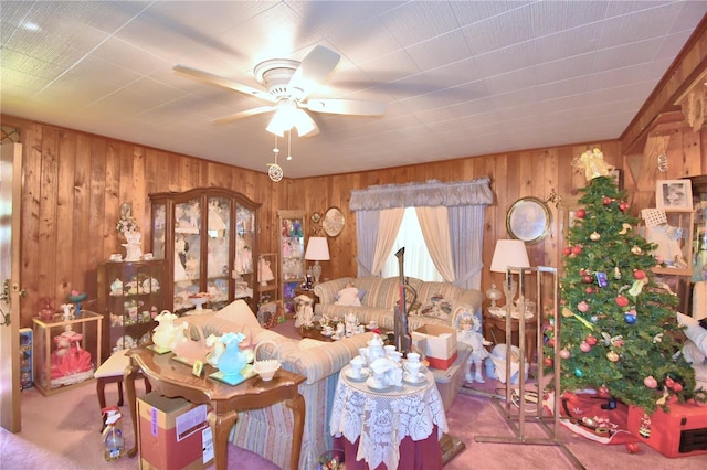 carpeted living room featuring ceiling fan and wooden walls