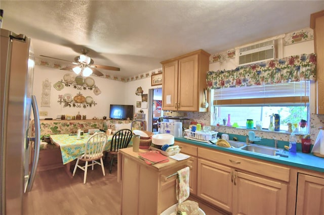 kitchen featuring stainless steel refrigerator, ceiling fan, light brown cabinets, sink, and hardwood / wood-style floors