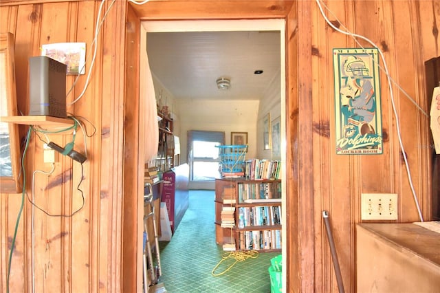 corridor featuring carpet floors and wood walls