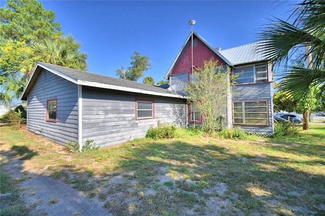 rear view of house featuring a yard