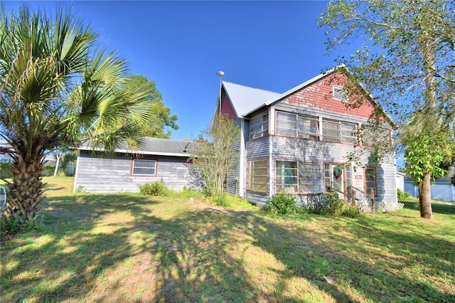 rear view of house featuring a yard