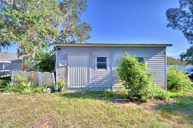 view of side of property featuring an outbuilding and a yard