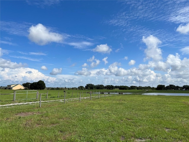 view of yard with a water view and a rural view