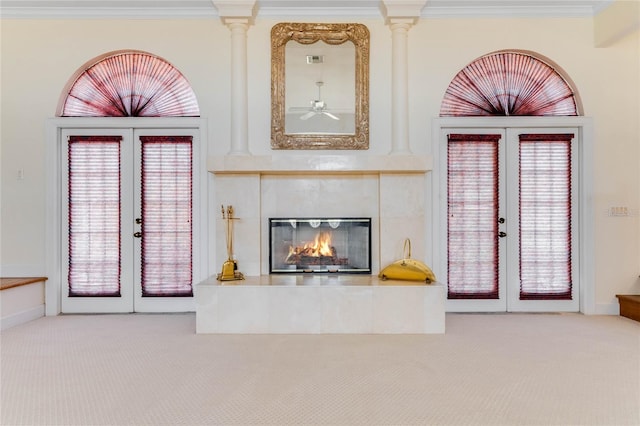 unfurnished living room featuring light carpet, crown molding, french doors, and a tiled fireplace