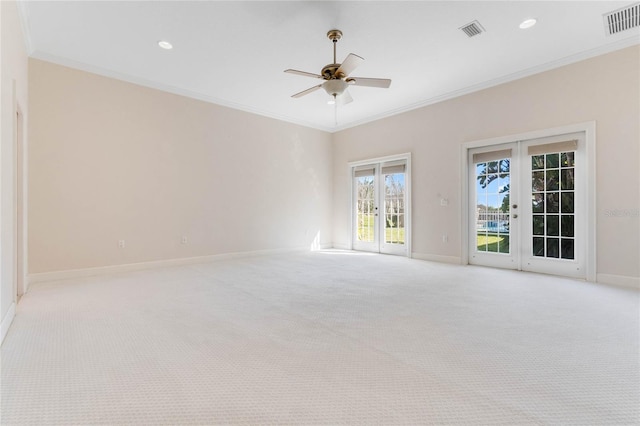 carpeted empty room with french doors, ceiling fan, and ornamental molding