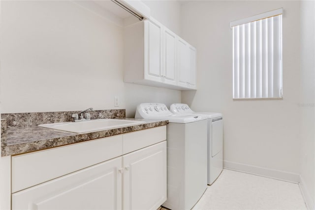 clothes washing area featuring cabinets, washing machine and clothes dryer, and sink