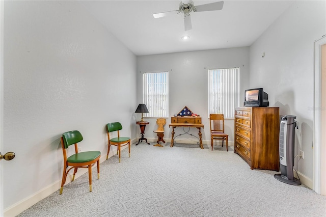 living area featuring ceiling fan and carpet