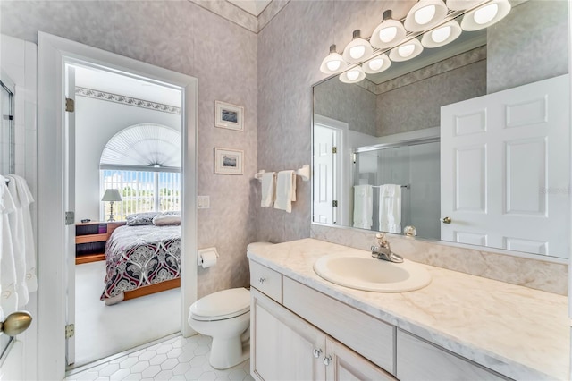 bathroom featuring vanity, toilet, and a shower with door