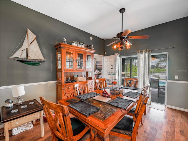dining space featuring ceiling fan and dark wood-type flooring