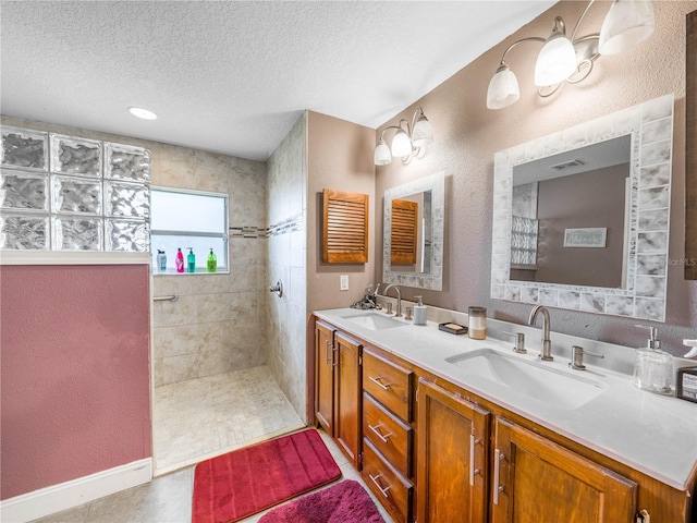 bathroom featuring tile floors, dual vanity, and a textured ceiling