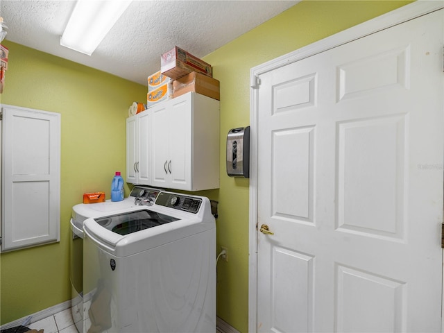 washroom with a textured ceiling, cabinets, independent washer and dryer, and light tile floors