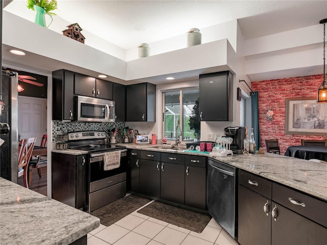 kitchen with hanging light fixtures, backsplash, ceiling fan, stainless steel appliances, and light tile floors