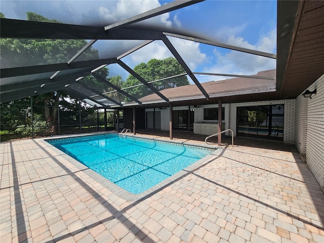 view of pool featuring glass enclosure and a patio area