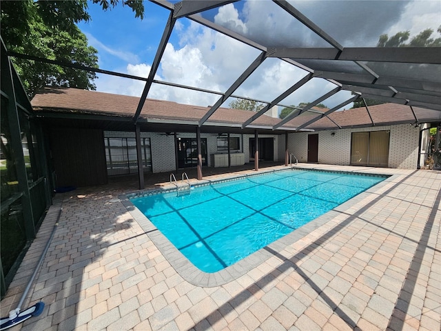 view of swimming pool featuring a patio area and a lanai