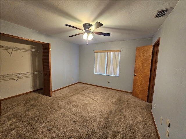 unfurnished bedroom with a closet, ceiling fan, carpet, and a textured ceiling