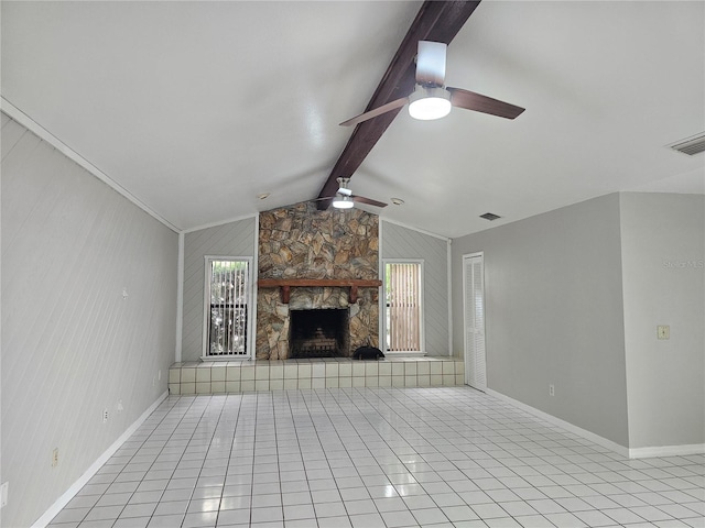 unfurnished living room with wood walls, a fireplace, light tile patterned floors, lofted ceiling with beams, and ceiling fan