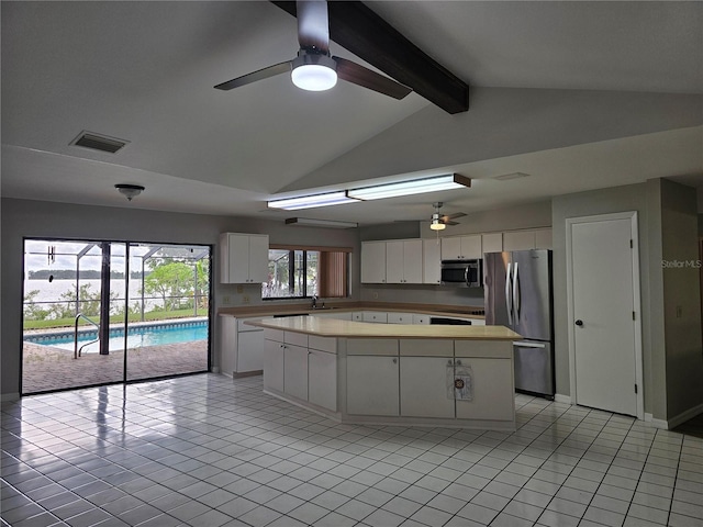 kitchen with white cabinetry, a center island, ceiling fan, vaulted ceiling with beams, and appliances with stainless steel finishes