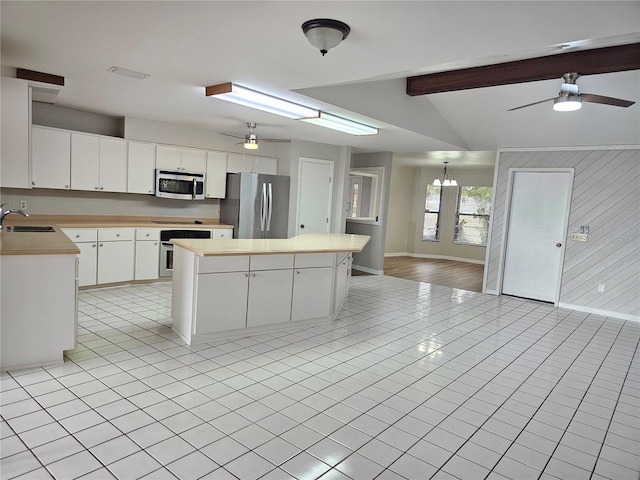 kitchen featuring ceiling fan with notable chandelier, white cabinetry, a kitchen island, sink, and appliances with stainless steel finishes