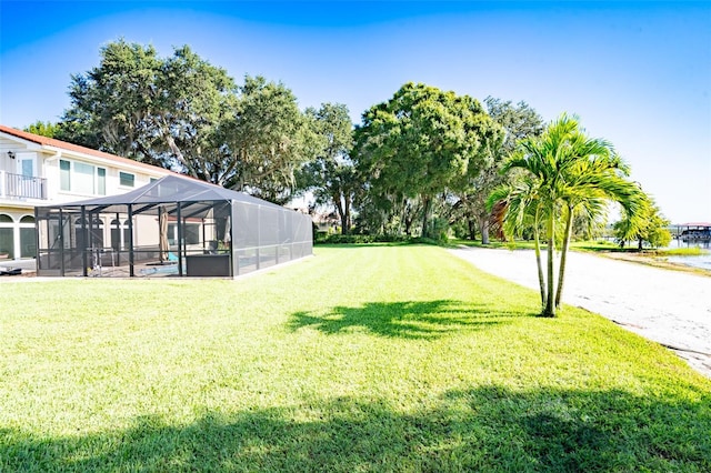 view of yard with a swimming pool, a balcony, and glass enclosure