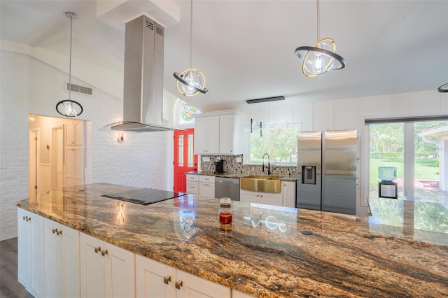 kitchen featuring range hood, white cabinets, appliances with stainless steel finishes, a wealth of natural light, and lofted ceiling