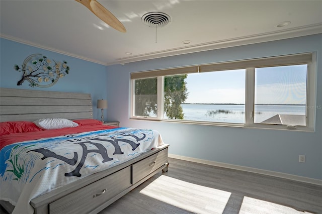 bedroom featuring crown molding, wood-type flooring, and ceiling fan