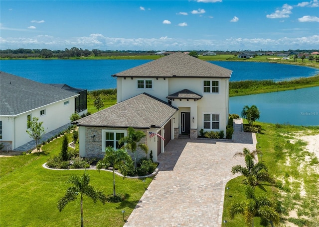 view of front of property featuring a water view and a front lawn