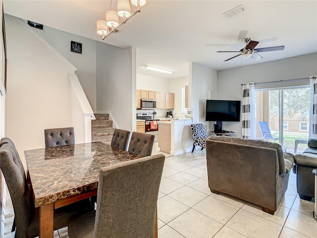 tiled dining area with ceiling fan with notable chandelier