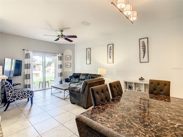 living room featuring ceiling fan with notable chandelier and light tile flooring