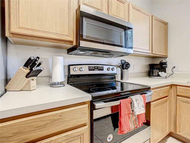 kitchen with light brown cabinets, light tile floors, and appliances with stainless steel finishes