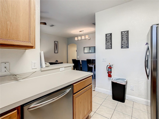 kitchen featuring light tile floors, hanging light fixtures, a chandelier, and stainless steel appliances