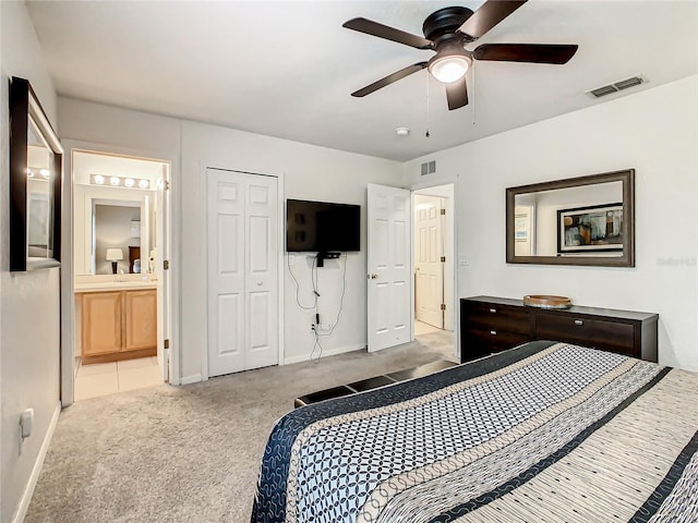 carpeted bedroom featuring ensuite bath, a closet, and ceiling fan