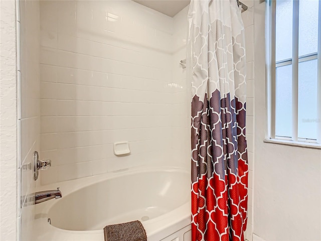 bathroom with shower / bathtub combination with curtain and a wealth of natural light