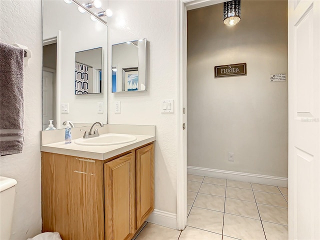 bathroom with toilet, vanity, and tile flooring