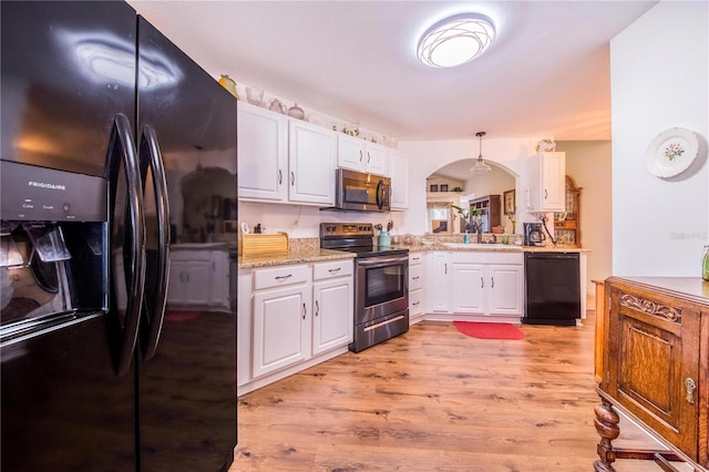 kitchen featuring decorative light fixtures, sink, black appliances, and white cabinets