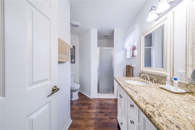 bathroom with wood-type flooring, toilet, walk in shower, and vanity