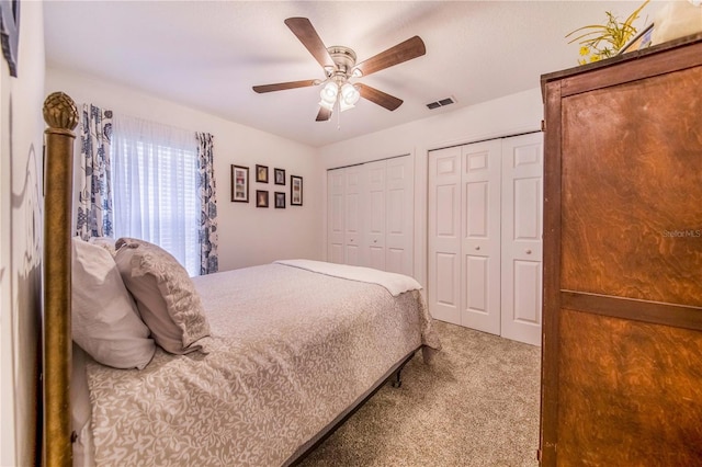 bedroom featuring ceiling fan, two closets, and carpet