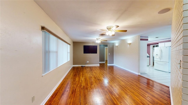 empty room with ceiling fan and hardwood / wood-style floors