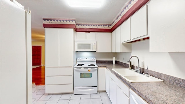 kitchen featuring sink, white appliances, white cabinets, and light tile patterned floors