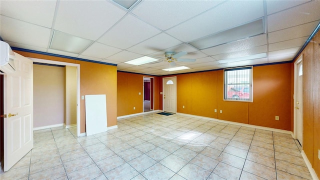 unfurnished room with a paneled ceiling, ceiling fan, light tile patterned floors, and a wall mounted AC