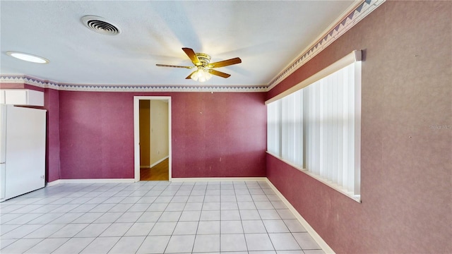 unfurnished room featuring light tile patterned flooring, a wealth of natural light, ornamental molding, and ceiling fan