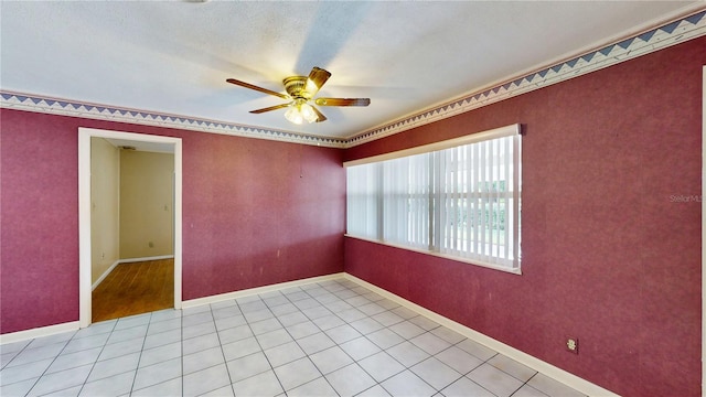 spare room featuring ceiling fan, crown molding, and light tile patterned flooring