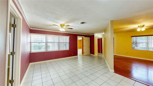 tiled empty room with ceiling fan and plenty of natural light