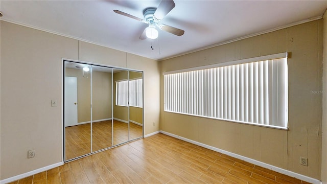 unfurnished bedroom featuring a closet, ceiling fan, crown molding, and hardwood / wood-style flooring