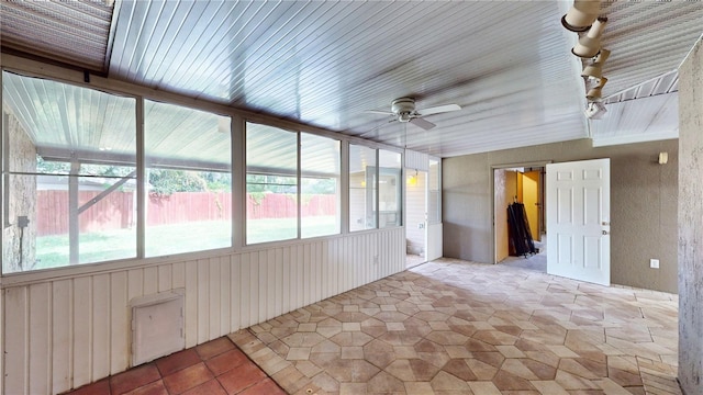 unfurnished sunroom featuring ceiling fan