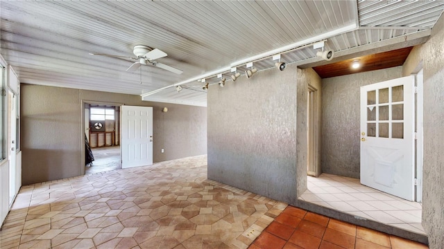 tiled empty room with ceiling fan and track lighting